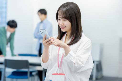 オフィスでスマホを持つビジネスウーマン スマホ,笑顔,ビジネスウーマンの写真素材