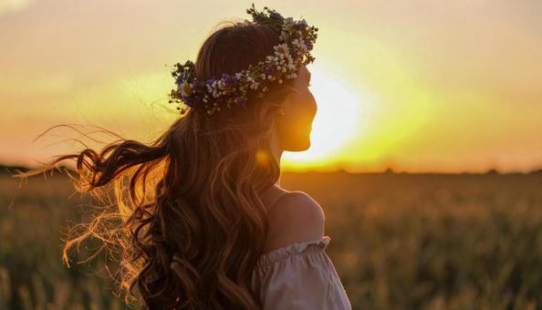 花輪のティアラをつけた女性が夕日に佇む 花輪のティアラをつけた女性が夕日に佇むの写真