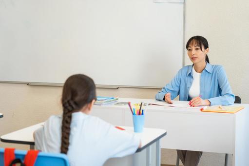女の子に説明するネイルをした先生 女性,女の子,子どもの写真素材