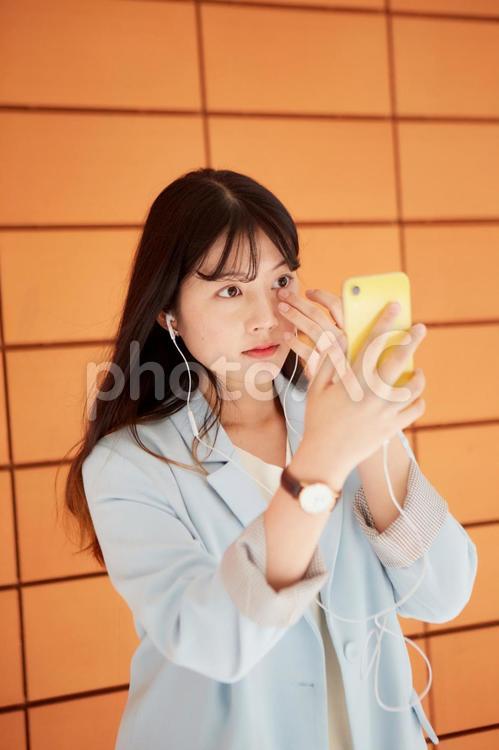 スマホを鏡代わりにする日本人女性2 女性,日本人,アジア人の写真素材
