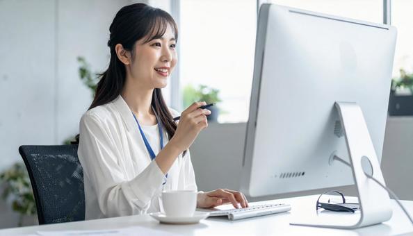 パソコンに向かって話す女性 パソコンに向かって話す女性の写真