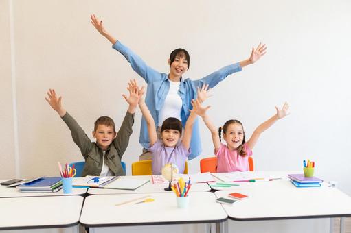 カメラ目線で喜ぶ先生と生徒たち 女性,女の子,男の子の写真素材