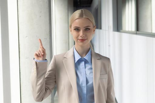 オフィスの通路で人差し指を立てているビジネスウーマン ビジネスウーマン,ビジネス,女性の写真素材