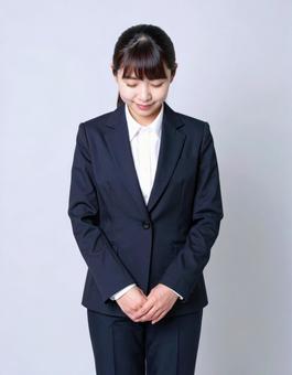 お辞儀するスーツ女性のビジネスマナーの写真