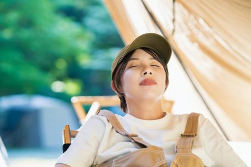 Solo camp image young woman taking a nap in front of a tent, lager, solo-camp, fem, JPG