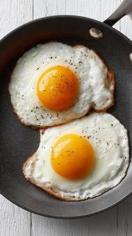 輝く黄身が美味しそうな目玉焼き 輝く黄身が美味しそうな目玉焼きの写真