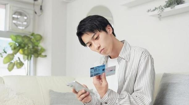 マイナ保険証を設定するアジア人男性 男性,マイナ保険証,マイナンバーカードの写真素材