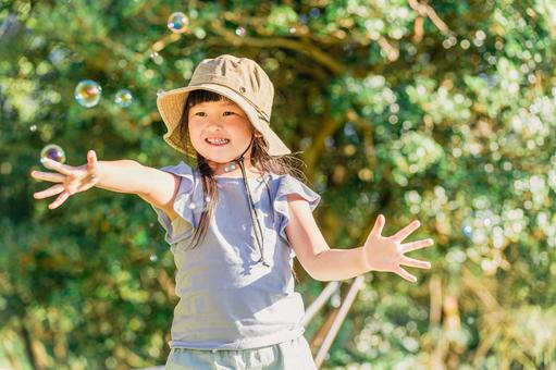キャンプ場でシャボン玉を追いかける子供 アウトドア,子供,遊ぶの写真素材
