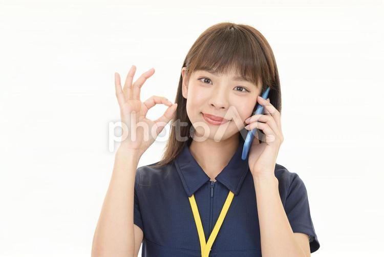 スマートフォンを持つ女性店員 ビジネス,女性,作業員の写真素材