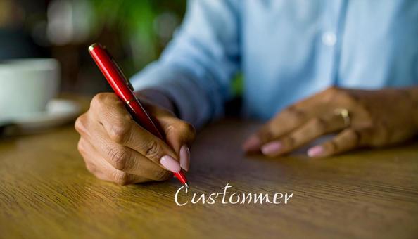 文字CUSTOMERと赤ペンで書く女性 文字CUSTOMERと赤ペンで書く女性の写真