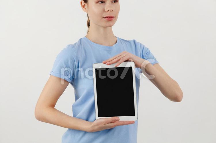 タブレットの上と下を押さえ持つ女性 女性,タブレット,画面の写真素材