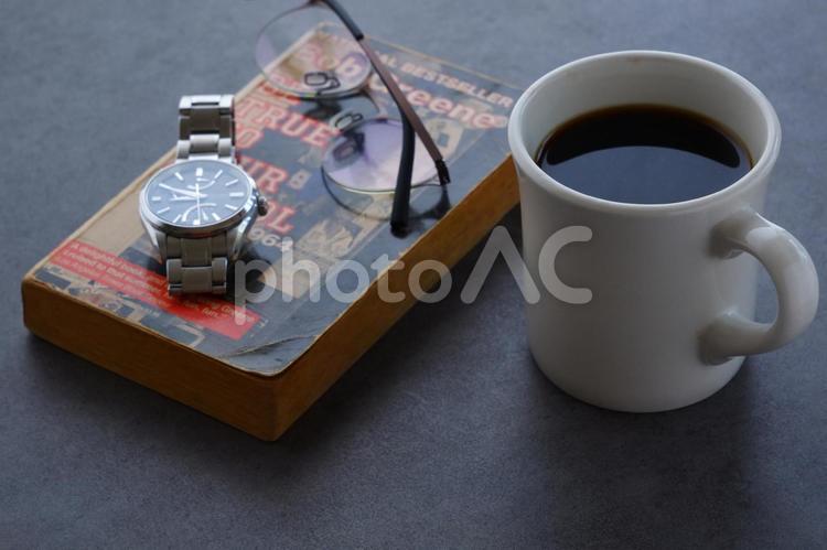 本とメガネ、コーヒーの入ったマグカップ 本,メガネ,テーブルの写真素材
