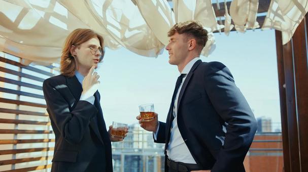 飲み物を持ち話す横向きの外国人男性 男性,外国人,笑顔の写真素材