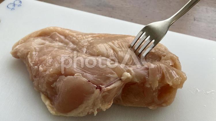 鶏むね肉（フォークで刺している） 鶏むね肉,胸肉,鶏肉の写真素材