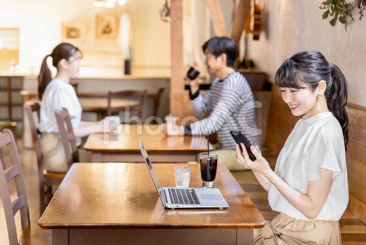 カフェでスマホを使うフリーランスの女性 スマホ,カフェ,pcの写真素材