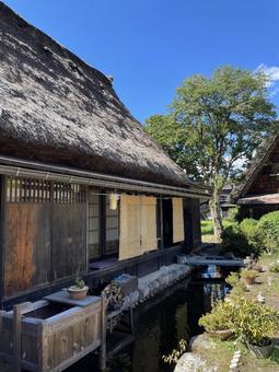 水路の近くにある白川郷の合掌造り 水路の近くにある白川郷の合掌造り 空,青空,雲の写真素材