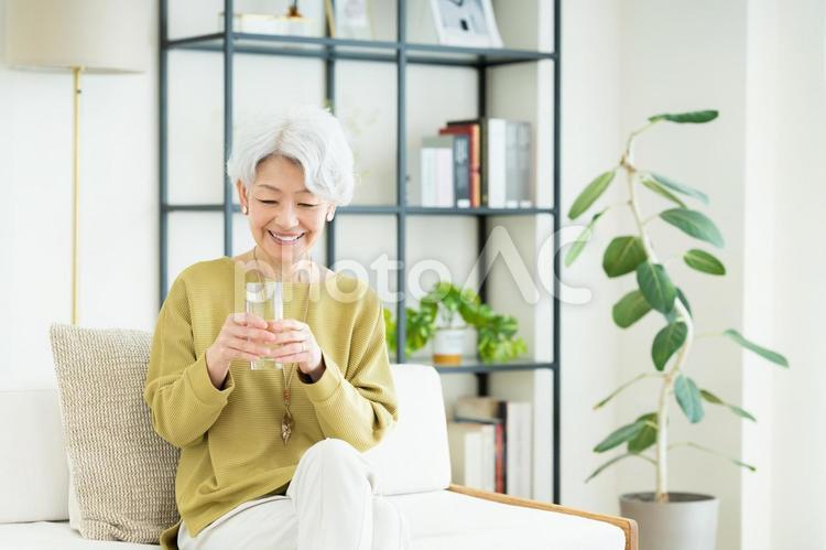 ミネラルウォーターを飲むシニアの女性 ミネラルウォーター,水,飲むの写真素材