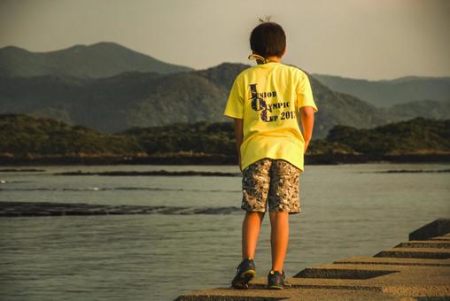 <素材>堤防から夕暮れの海を眺める男の子 <素材>堤防から夕暮れの海を眺める男の子 子供,男性,人物の写真素材