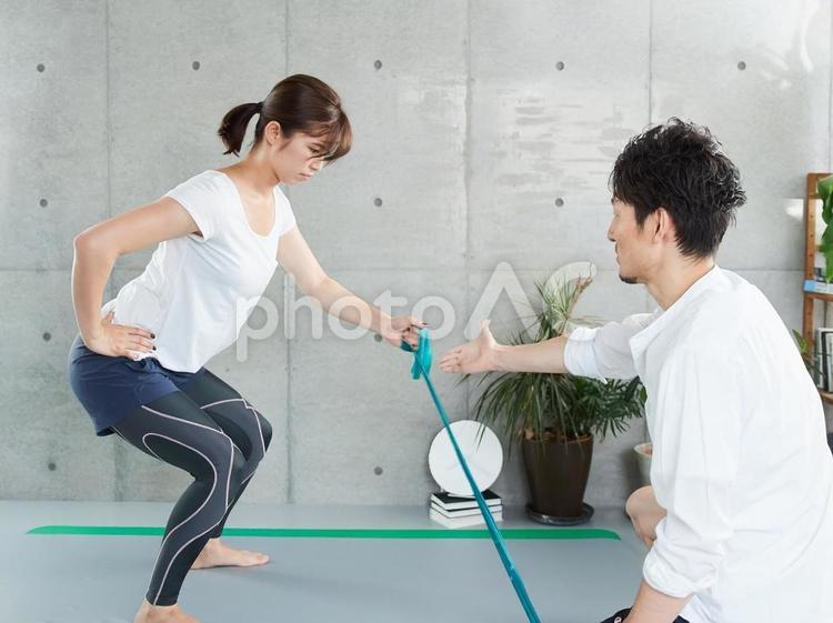 チューブトレーニングの指導を受ける女性 パーソナルトレーニング,指導,ジムの写真素材