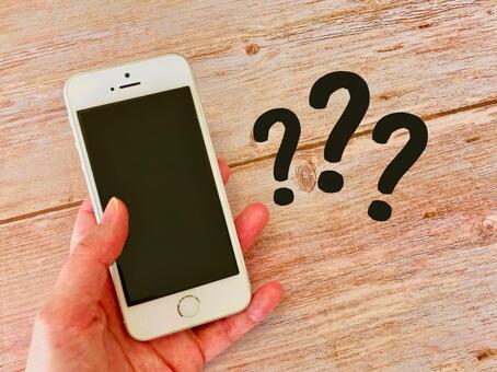 スマホを持つ手元とクエスチョンマーク スマホ,操作,設定の写真素材