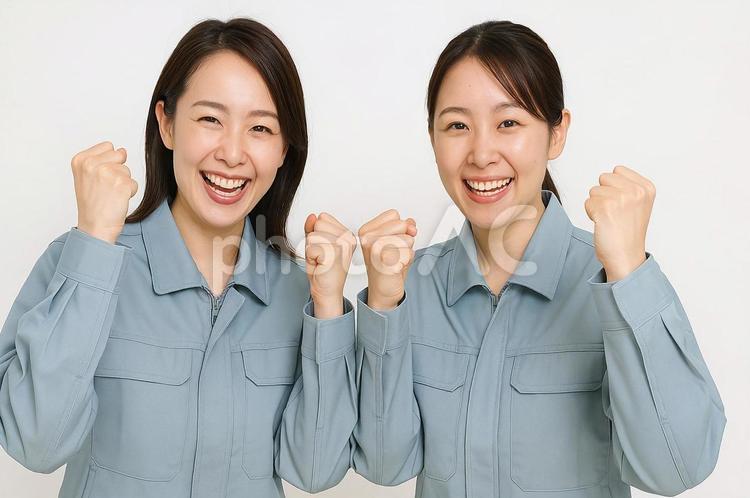 作業服姿でガッツポーズする笑顔の女性2人 作業服,ガッツポーズ,笑顔の写真素材