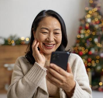 スマホ 嬉しい知らせ 60代 女性 部屋  スマホ 嬉しい知らせ 60代 女性 部屋 の写真