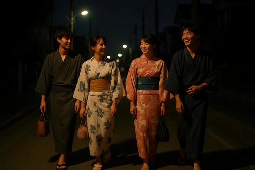 花火大会の帰り道を歩く浴衣姿の若者たち 花火大会の帰り道を歩く浴衣姿の若者たちの写真