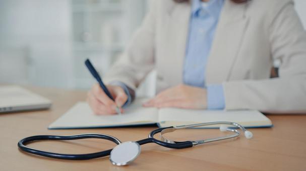 聴診器を前に書き込む手元 保険業,事務職,接客業の写真素材