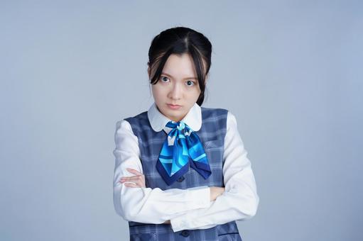 青いリボンの制服の女性が腕を組んで見つめる 女性,腕組み,怒るの写真素材