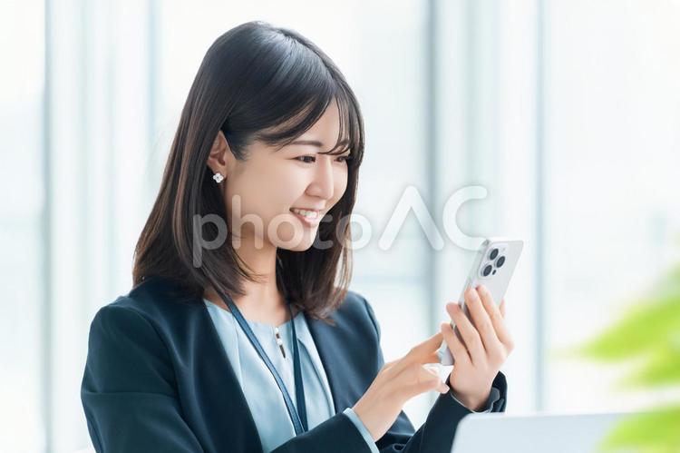 スマホを使う笑顔の女性・ビジネスウーマン 女性,スマホ,人物の写真素材