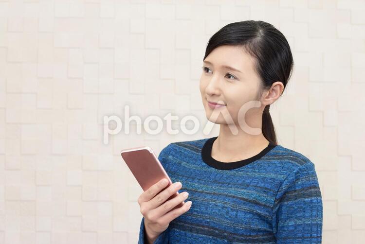 スマートフォンを持つ笑顔の女性 女性,スマートフォン,女の写真素材