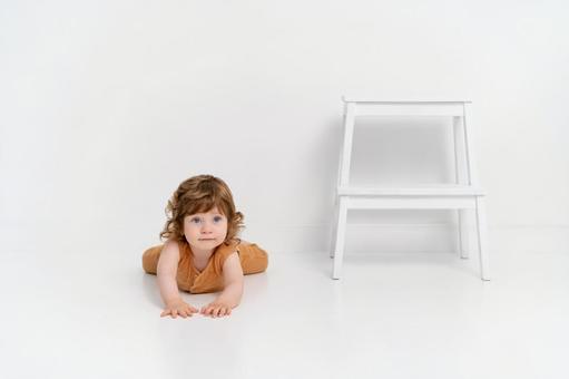 白い床の上でハイハイポーズのくせ毛の子供 白い床の上でハイハイポーズのくせ毛の子供 赤ちゃん,かわいい,ハイハイの写真素材