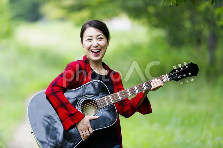 ギターを抱える女性 人物,女性,ギターの写真素材