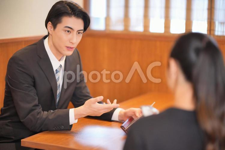 メニューを見て注文する男性と女性店員の後ろ姿 男性,男女,大学生の写真素材