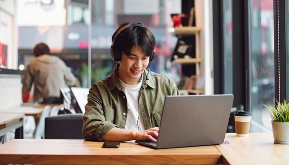 カフェで仕事をするフリーランス男性 カフェで仕事をするフリーランス男性の写真
