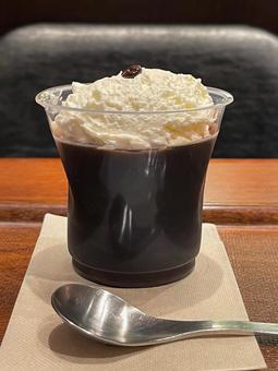 クリームの乗ったコーヒーゼリーとスプーン クリームの乗ったコーヒーゼリーとスプーンの写真