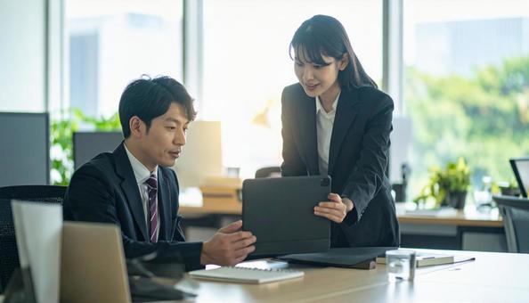 タブレットで打ち合わせするビジネス社員 タブレットで打ち合わせするビジネス社員の写真