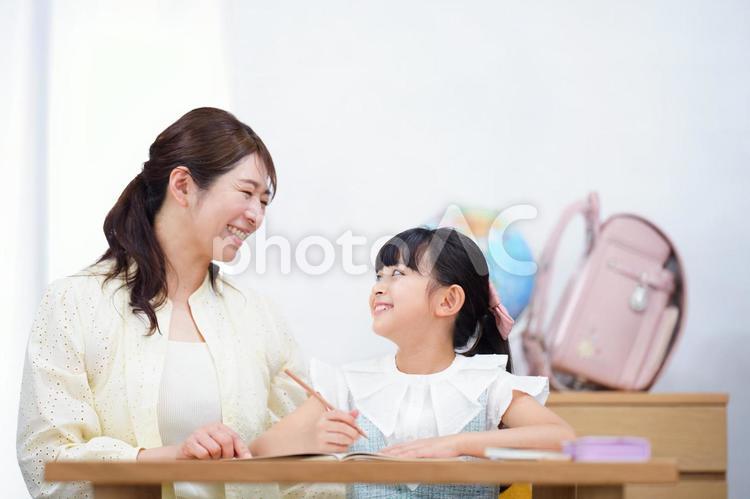 鉛筆を持ち母を見る女の子 娘,振り向く,母の写真素材