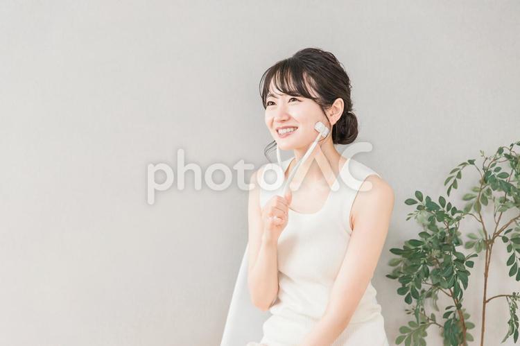 美顔ローラーを使ってマッサージする女性 美顔ローラー,ローラー,顔痩せの写真素材