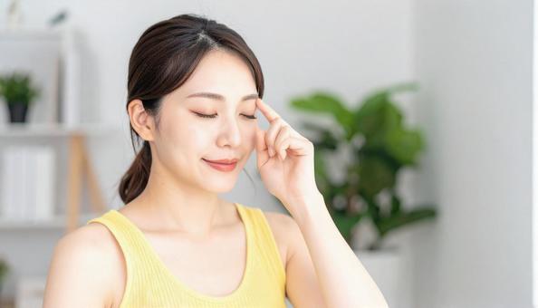 目をつむり目を指差す女性 目をつむり目を指差す女性の写真