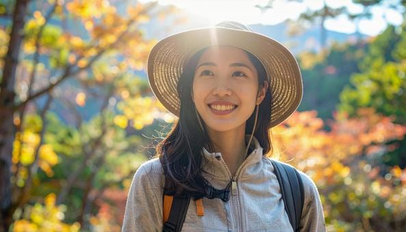 秋の山をトレッキング・登山する日本人女性の写真