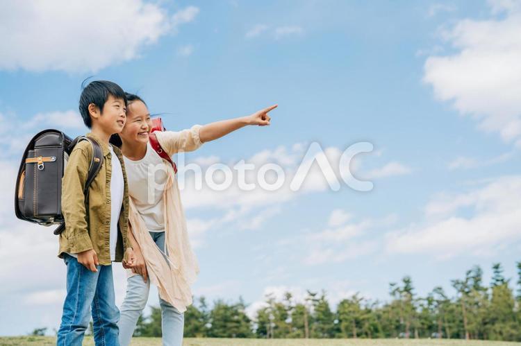 空と小学生（指差す） 小学生,空,子供の写真素材