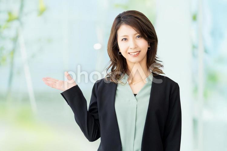手で案内をする女性・ビジネスウーマン 女性,笑顔,案内の写真素材