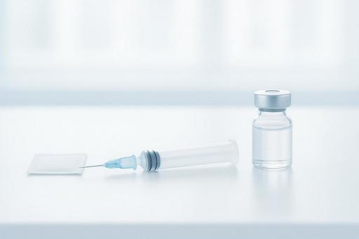 注射器とアンプルとガーゼの写真