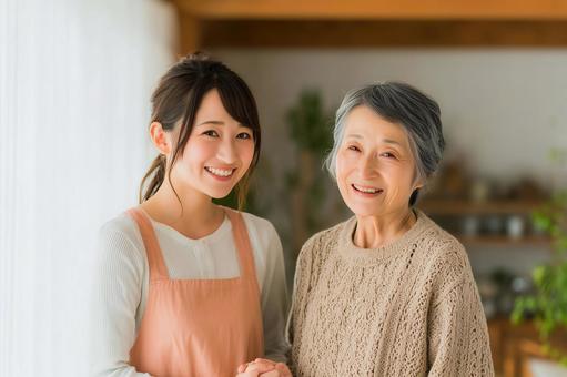笑顔で寄り添う若い女性介護士とシニア女性の写真