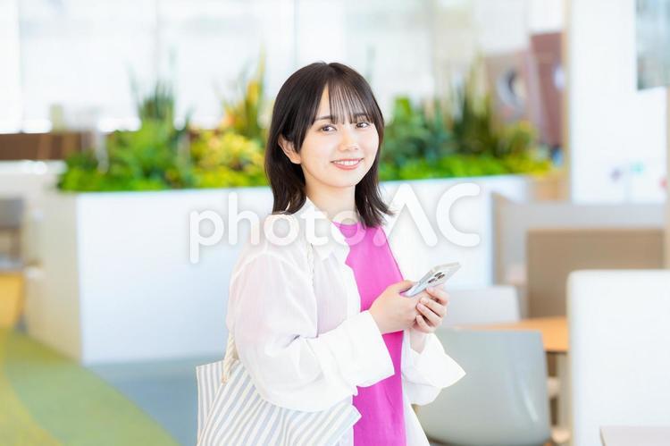 スマホを見る笑顔の女性 スマホ,若い女性,笑顔の写真素材