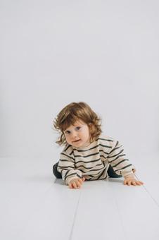カメラ目線でハイハイするボーダー柄の子供 カメラ目線でハイハイするボーダー柄の子供 赤ちゃん,かわいい,ハイハイの写真素材