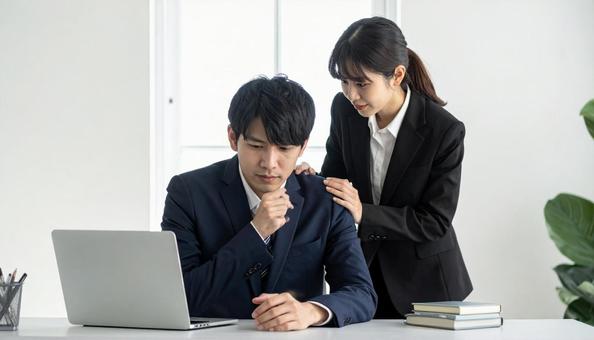 落ち込む男性を慰めるビジネスウーマン 落ち込む男性を慰めるビジネスウーマンの写真