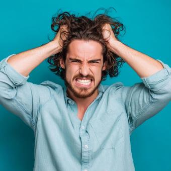 悩んで頭を抱える男性 悩んで頭を抱える男性の写真