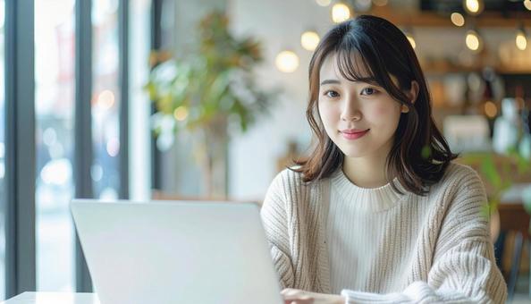 カフェでノートパソコンを使う日本人女性 カフェでノートパソコンを使う日本人女性の写真